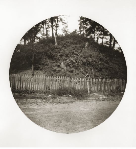 South side view of an Indian Mound with a fence in front of it.