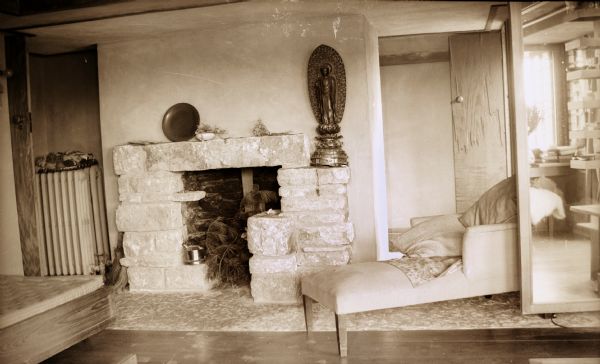 The fireplace and wall in the bedroom of Olgivanna Wright at Taliesin, the summer home of architect Frank Lloyd Wright and the Taliesin Fellowship.  A chaise lounge is in front of the fireplace. Taliesin is located in the vicinity of Spring Green, Wisconsin.