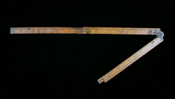 A wooden folding ruler for measuring, with a portion broken off.