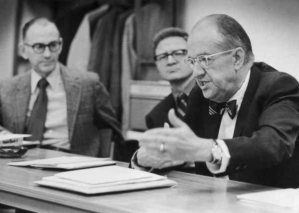 Richard W.E. Perrin, seen speaking in the foreground, discusses plans in a meeting for an outdoor museum of ethnic history in Kettle Moraine. Professor Victor R. Green of University of Wisconsin-Milwaukee sits on the left.