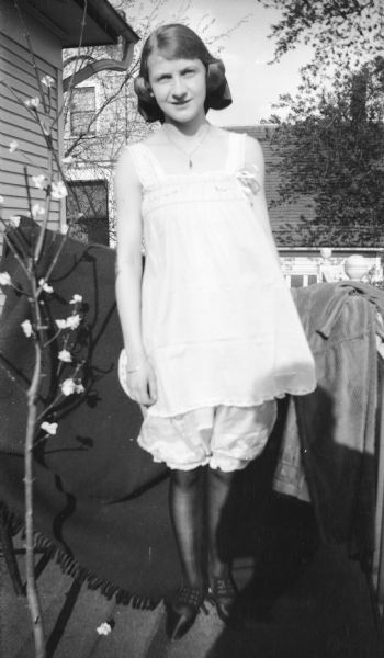 Mary Brandel poses outdoors on a porch in what appears to be undergarments or sleepwear.