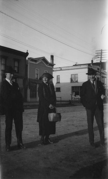 Members of the Brandel family (probably), two men and one woman, pose on Main Street.