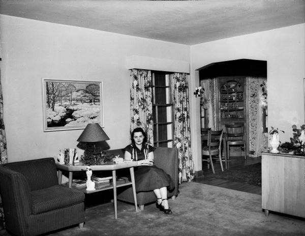 The living room of the Byron and Mary Burch home, 205 South Owen Drive. Mary Burch is shown seated in a chair.