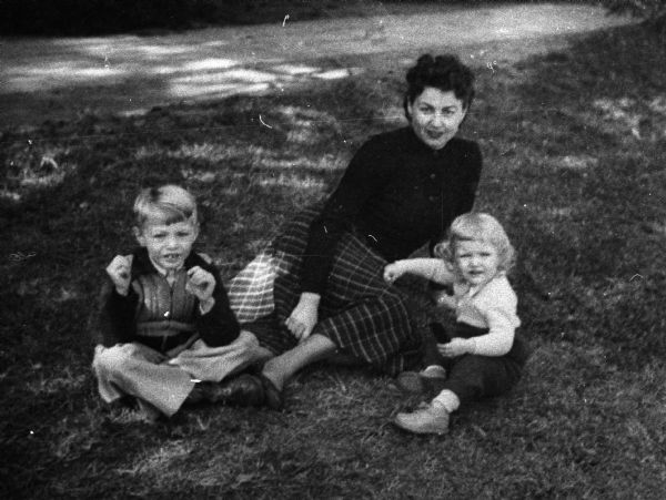 Magda Herzberger sitting on a lawn outside of Beilinson Hospital in Tel Aviv, Israel, with her son Henry and daughter Monika.