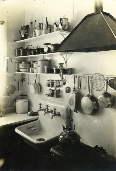 Interior view of a kitchen showing sink, stove, counter, and shelves. Apparently to demonstrate effective kitchen organization.