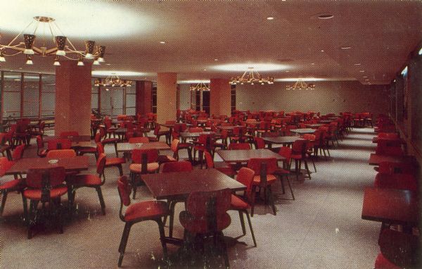 Interior view of the dining room at the Wisconsin Center for adult education at 702 Langdon Street, showing tables and chairs, and modern light fixtures.