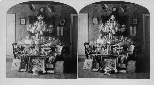 Stereograph of silver wedding anniversary gifts at the home of Dr. Galen Geer Rood (1830-1917) and his wife Nancy Jane (Sylvester) Rood (1834-1906). The Roods married in Stevens Point on either November 26, 1857 or 1858.