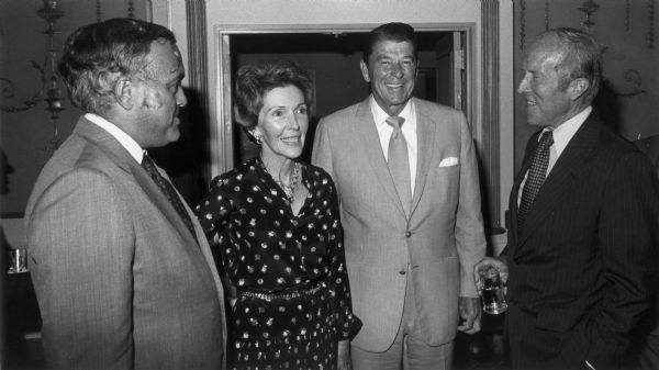 Journalists Robert Novak (left), and Rowland Evans (right) chat with Ronald and Nancy Reagan at a party hosted by RKO to kick off their new television program, "Evans-Novak Report." Reagan was later interviewed on the program.