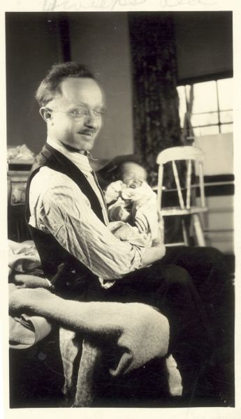 Rubin Levin posing holding his infant.
