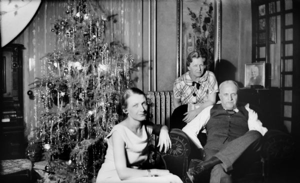 Edward and Mrs. Brandel and their daughter Mary pose near a Christmas tree during the holidays.