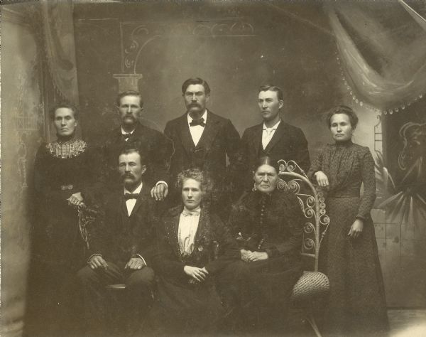 Studio portrait in front of a painted backdrop of the Eken family.