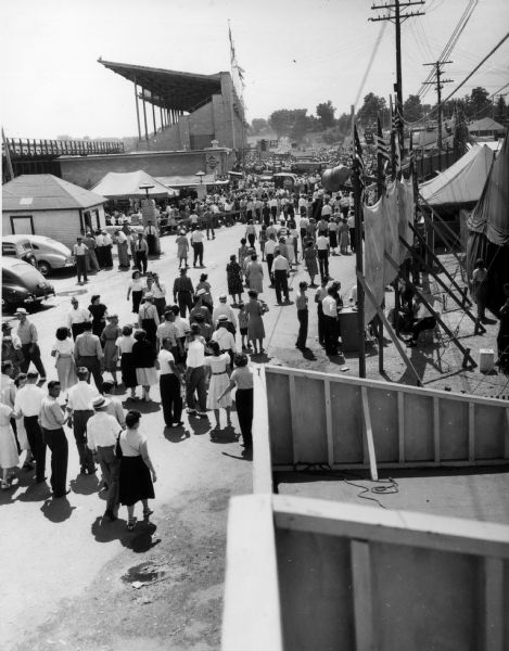 Elevated view of crowd of people outside of the grandstands at the Wisconsin State Fair grounds.