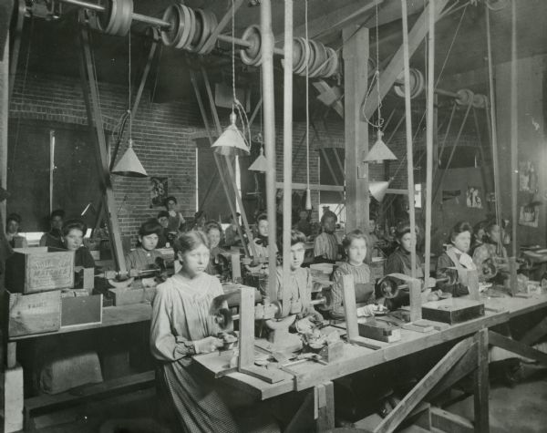 Women polishing aluminum items with belt-driven polishing machinery at Manitowoc Aluminum Novelty Co.