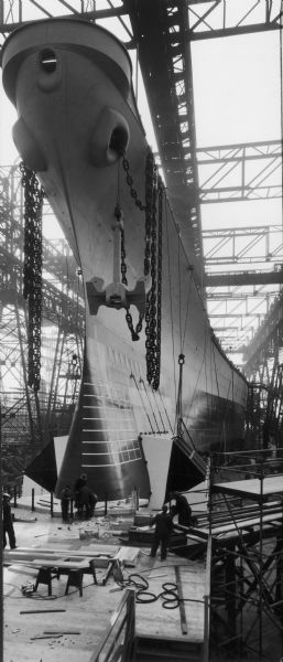 USS <i>Wisconsin</i> in drydock during construction. Men are working at the base of the ship.
