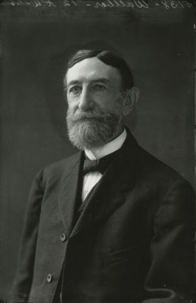 Waist-up studio portrait of Emil Wallber wearing a suit jacket, vest, and tie.