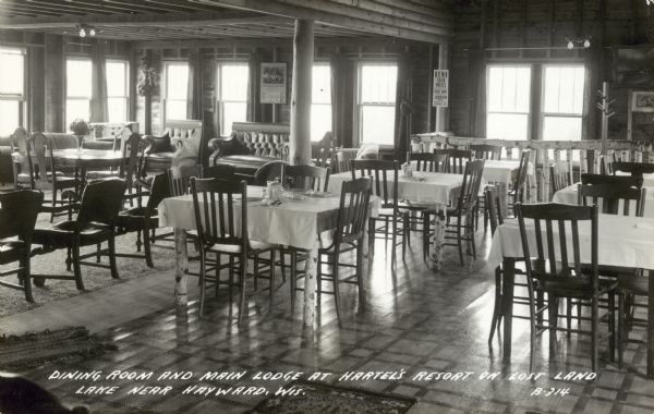 View of the dining room. Caption reads: "Dining room and main lodge at Hartel's Resort on Lost Land Lake near Hayward, Wis."