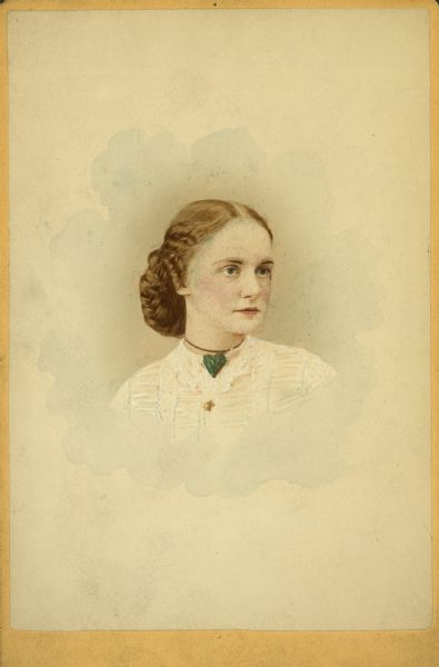 Hand-colored head and shoulders portrait of Elizabeth Comtock, who is wearing a blue heart pendant.