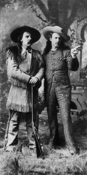 "Buffalo Bill" Cody and David Franklin Powell ("White Beaver") posing in in front of a painted backdrop in a Racine, Wisconsin gallery. This image was in the book <i>One For A Man, Two For A Horse</i> by Gerald Carson.