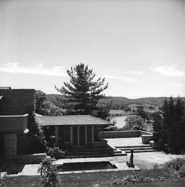 Exterior of Frank Lloyd Wright's bedroom, looking southeast, at Taliesin, the summer home of Frank Lloyd Wright. In the courtyard is a sculpture near a pool surrounded by stone. Taliesin is located in the vicinity of Spring Green, Wisconsin.