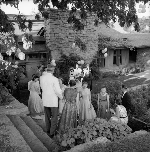 Elevated view of guests at Frank Lloyd Wright's 89th party in the courtyard of Taliesin. Taliesin is located in the vicinity of Spring Green, Wisconsin.