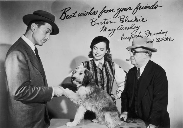 Boston Blackie (played by Kent Taylor), Mary Wesley (Lois Collier), and Inspector Faraday (Frank Orth), the cast of the television show <i>Boston Blackie</i>, pose with Whitey the Dog. This photograph includes three signatures.