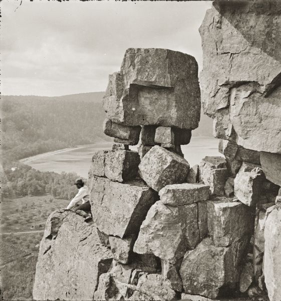 Devil's Lake vicinity; Boulders on top of cliff, at foot of Devil's Doorway; man on the left.