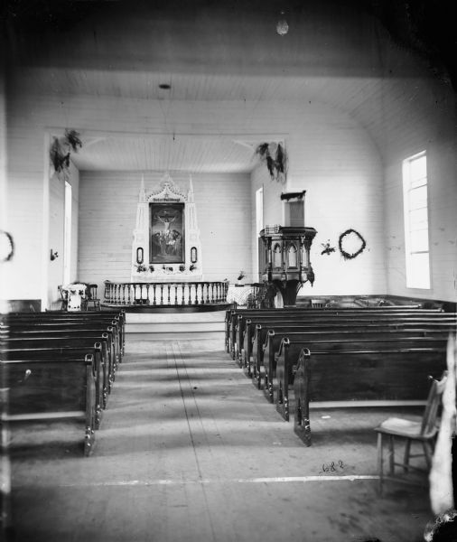 "View of the interior of the church" from the "Dedication of Blue Mounds Church" section of Dahl's 1877 "Catalogue of Stereoscopic Views." The church was dedicated on August 30, 1876. The church was formerly Norsk Evangelisk Kirke, built in 1868.