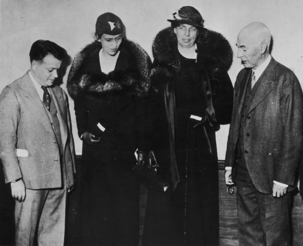 Eleanor Roosevelt and her daughter Anna have the NRA labels in their coats inspected by David Dubinsky, president of the ILG WU (left) and Raymond Ingersoll, impartial chairman of the Cloak and Suit Industry.