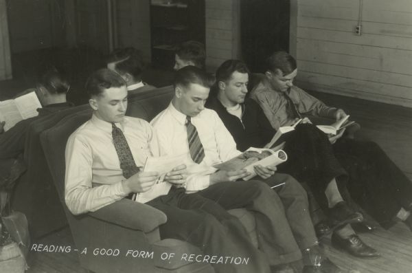 Several young men, probably students, are seated side by side on a couch reading books. The caption beneath the image reads "Reading--A Good Form of Recreation."