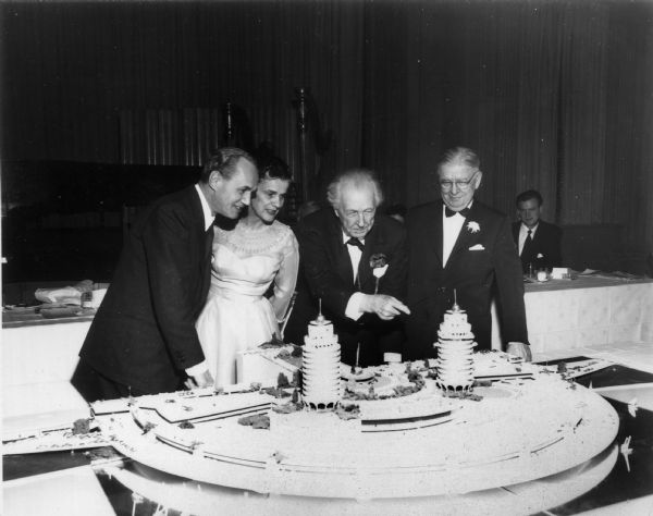 Frank Lloyd Wright and Mrs. Wright at a Madison event honoring him.  They are looking at a model of the Wright-designed model of Monona Terrace. With them (left) are Governor Walter Kohler, Jr., and (right) William T. Evjue, of the <i>Madison Capital Times</i>.