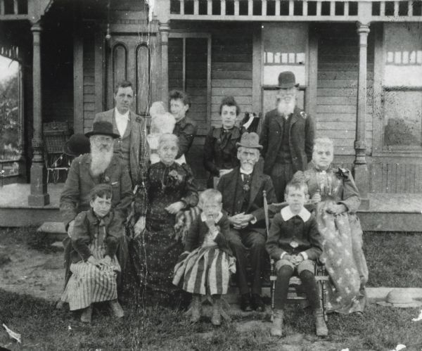 Tanner family posed outside the porch of a house.