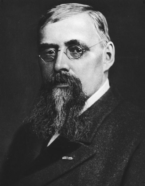 Head and shoulders portrait of a bearded James B. Pond wearing eyeglasses and his Medal of Honor rosette.