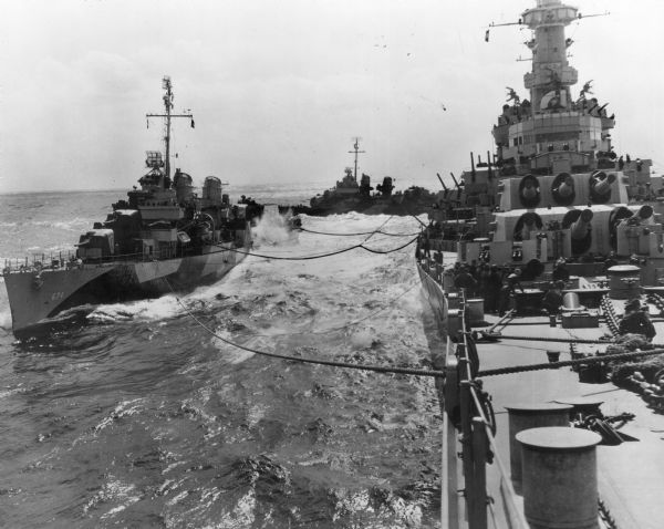 View from the USS <i>Wisconsin</i> making contact with two destroyers at sea. The ships are transferring fuel.