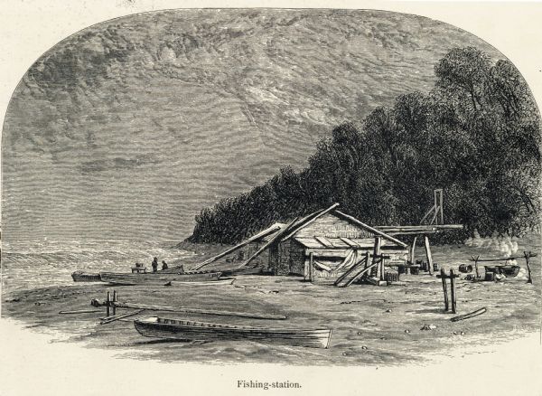 Engraving of a wooden shack on a Lake Michigan beach surrounded by rowboats, a campfire, and a wooded bluff. Two men stand on the beach near the water.