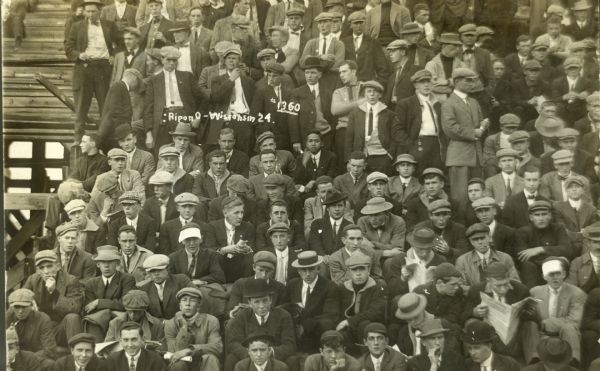 A view of the University of Wisconsin football fans at Camp Randall during the game against Ripon College, which UW won 24-0.  Student Ralph Engsberg, who sent this postcard to his girlfriend, is denoted by #1360.