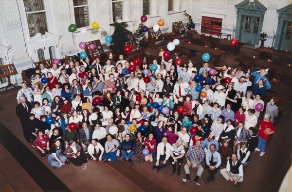 Color portrait of the Historical Society staff. This image is a humorous version with balloons of another image which was taken for the cover of a special issue of the <i>Wisconsin Magazine of History</i> issued to mark the Historical Society's 100th anniversary.