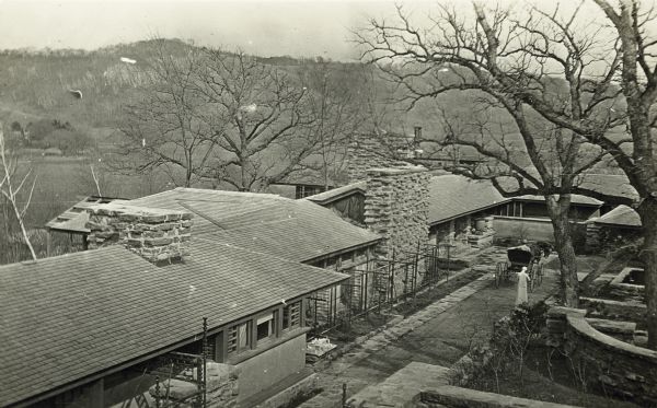 Elevated, exterior view of Taliesin, including a man in a horse-drawn carriage in the courtyard. Taliesin is located in the vicinity of Spring Green, Wisconsin.