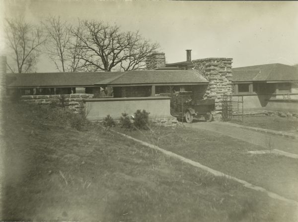 Exterior view of Taliesin with a vehicle, probably a truck, parked at the entrance gate. Taliesin is located in the vicinity of Spring Green, Wisconsin.