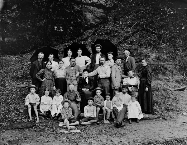 Henry Hamilton Bennett and his extended family posing outdoors with umbrellas.