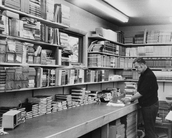 Wisconsin writer August Derleth examining the stock of the Arkham House press. He established it in Sauk City to publish in hard cover the works of H.P. Lovecraft.
