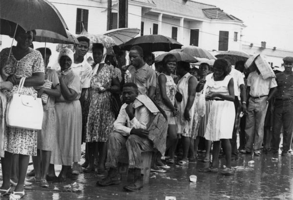 A group of flood victims stand in the rain after (Hurricane) Betsy at Algers Naval Base, where conditions were inadequate for them.