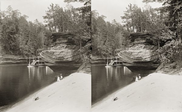 Stereograph of the steamboat the "Dell Queen" at Chapel Gorge. A woman and a young child sit on the shoreline.