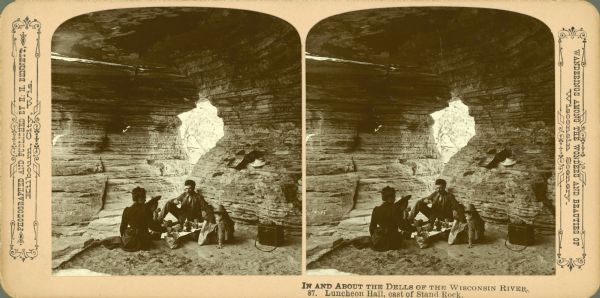 Stereograph of the Bennetts having a picnic in Luncheon Hall near Stand Rock. From left to right are Evaline Marshall Bennett, Miriam Bennett, John Bennett and Ruth Bennett. Text at right: "Wanderings Among the Wonders and Beauties of Wisconsin Scenery."