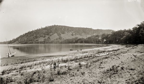 View of the beach at Devil's Lake, including a few boaters and sunbathers.