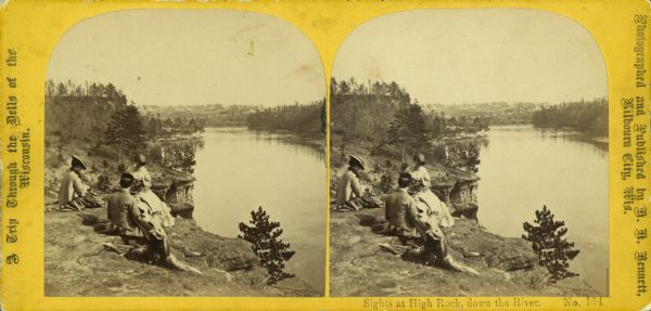 Stereograph of three fashionably-dressed people sitting at High Rock looking down over the Wisconsin River. Text at left: "A Trip Through the Dells of the Wisconsin."