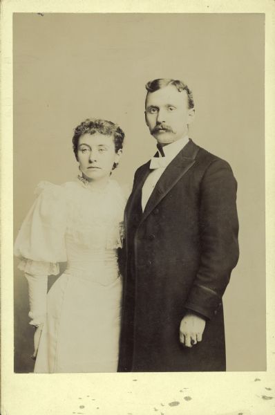 A three-quarter length wedding portrait of Nellie Bennett and George H. Crandall.