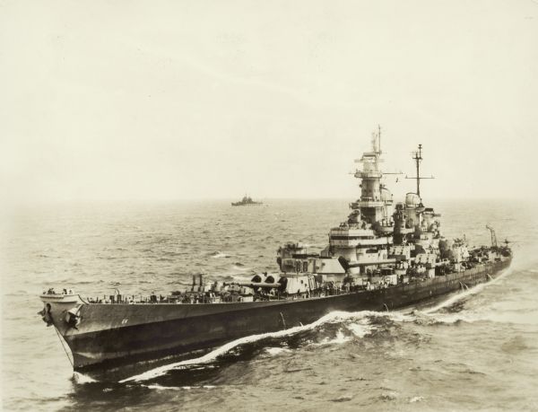 Elevated view of the battleship U.S.S. <i>Wisconsin</i> on the water. Another ship is in the background near the horizon.