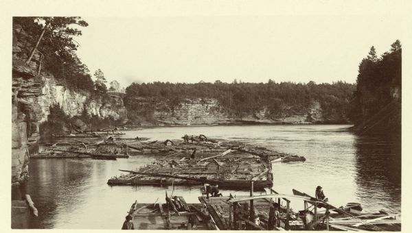 Elevated view of men working on lumber rafts on the Wisconsin River.