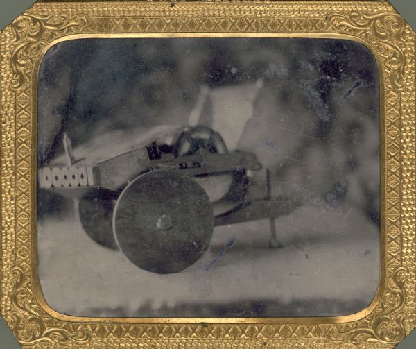 Tintype of a model gun intended to accompany a patent application. The five-barreled gun, invented by William Bradford, is mounted on wheels.