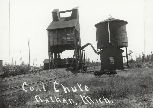 View of a coal chute with railroad tracks. On the right is a water tower.